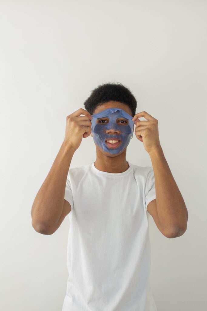 Cheerful black man in facial mask