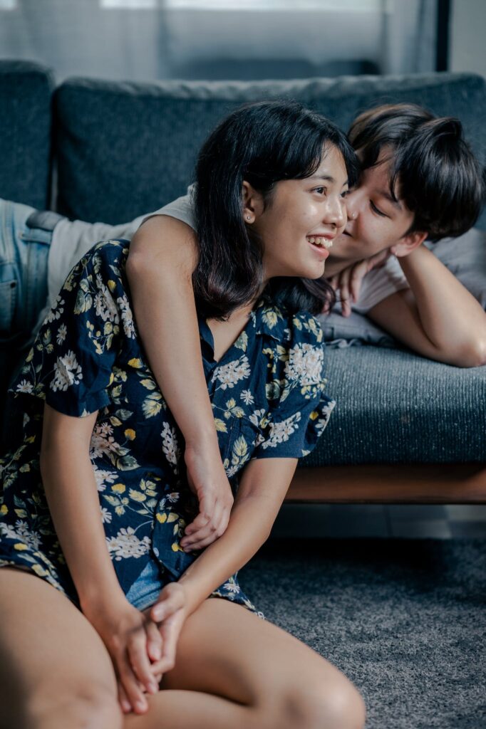 Photo of Couple Sitting on Couch and Floor